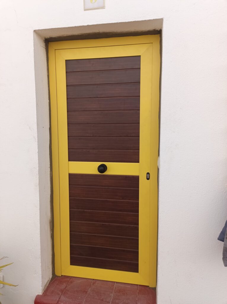 Puerta de aluminio en color amarillo. Aricruz.