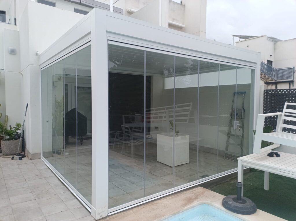 Pérgola bioclimatica con cerramiento de cortinas de cristal Acristalia.