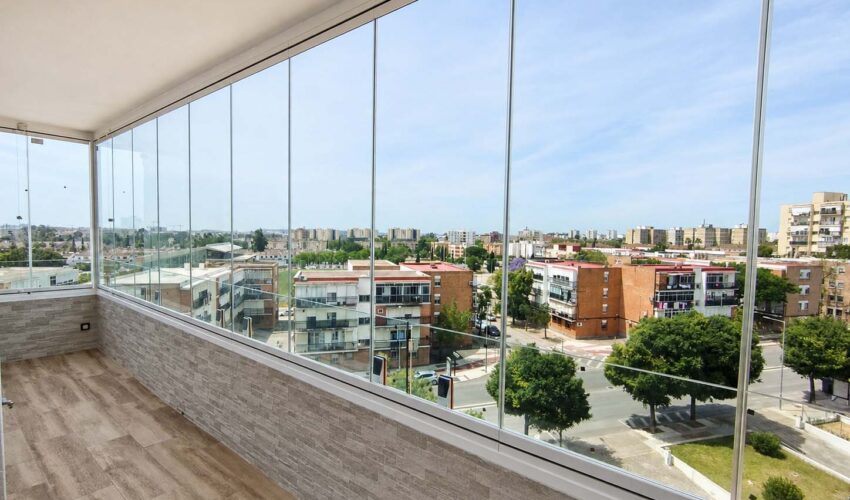 Cortinas de cristal instaladas en una terraza para crear un espacio exterior protegido y luminoso.